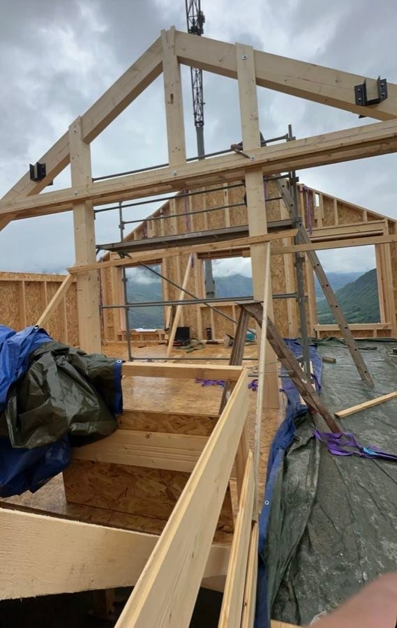 Ossature bois en cours de montage sur un chantier de construction en montagne